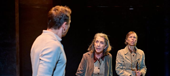 A production image from ‘Don’t Look Now.’ John, with his back turned to the camera listens to one of the sisters, who is speaking to him with some ferocity. The second sister stands behind, with a concerned expression on her face.