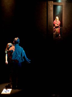 A production image from ‘Don’t Look Now.’ John, with his back to the camera, carries a young girl in his arms. He is looking up towards Laura who is standing in a doorway at the top of some stairs.