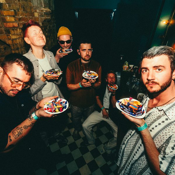 The band Bare Jams holding plates with individually wrapped chocolates