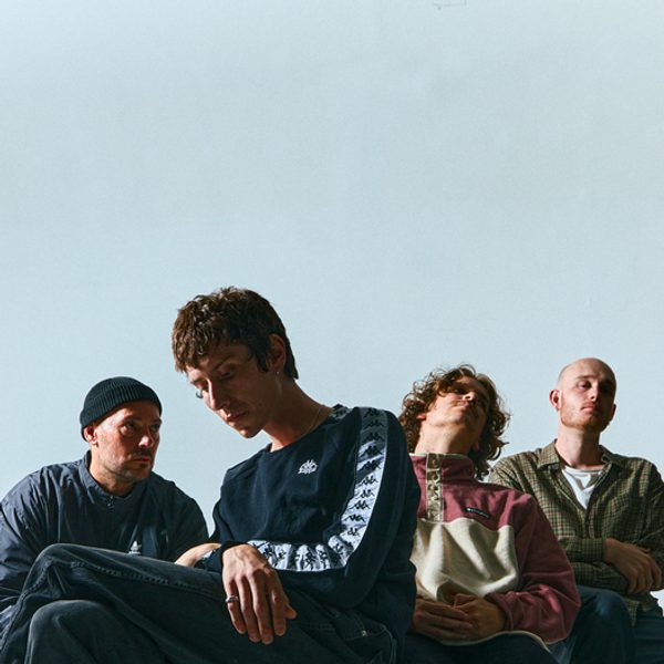 The four band members of False Futures in solemn poses, shot from below against a blue background.