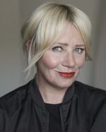 A headshot of East is East cast member Samantha Power. Her long hair is tied back and she's wearing black clothes.