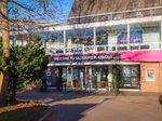 The front of Salisbury Playhouse, a theatre built in the 1970s that has been dressed to look like the Capulet mansion, with gold, burgundy, and green decorations. This is where you will arrive for the start of the show, and where various scenes will take place throughout.