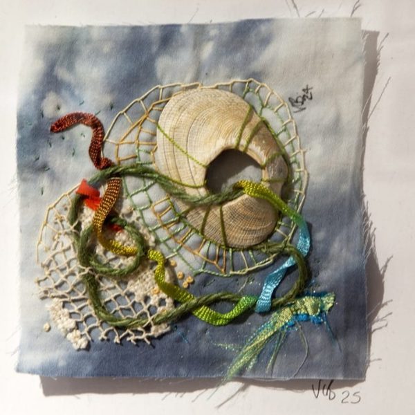 A photo of a piece of decorative embroidery, with several seashells stitched in.