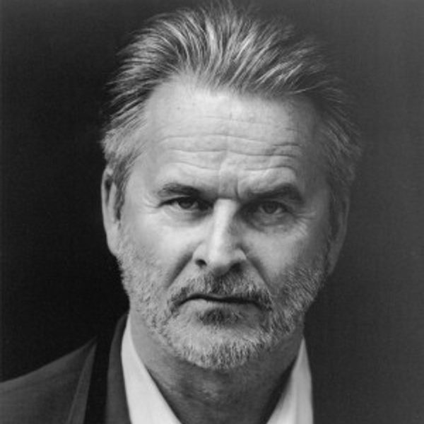 A black and white headshot of actor Trevor Eve, looking into the camera against a dark background.