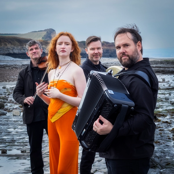 Members of band The Haar standing on a rocky beach