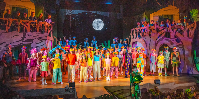 Full cast of The Jungle Book performing on stage.