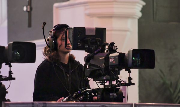 A young technician operating a camera