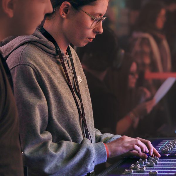 A young technician operating a sound desk