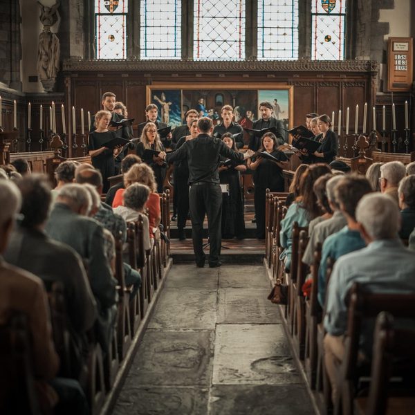 Continuum choir singing to an audience in a church.