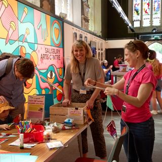 Wiltshire Creative staff and visitors making bunting at Family Fiesta