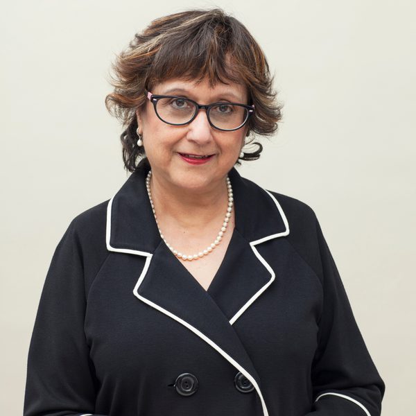 Journalist Yasmin Alibhai-Brown dressed in a black jacket and facing the camera.